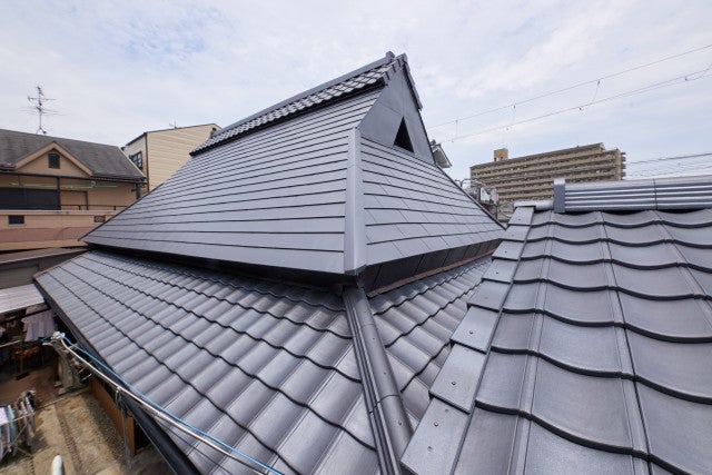 写真:茅葺き屋根を温存したまま、上部の屋根の張り替えをご提案。最新の機能性をもちながらも、和風屋根を表現できるルーガ(軽量瓦)とガルバリウム鋼板を使った一文字葺きの組み合わせでご提案いたしました。